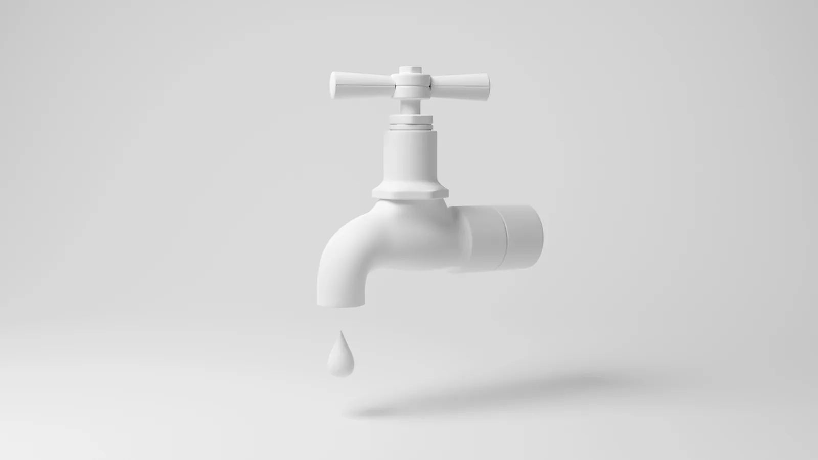 A white faucet releasing a single drop against a pale grey background