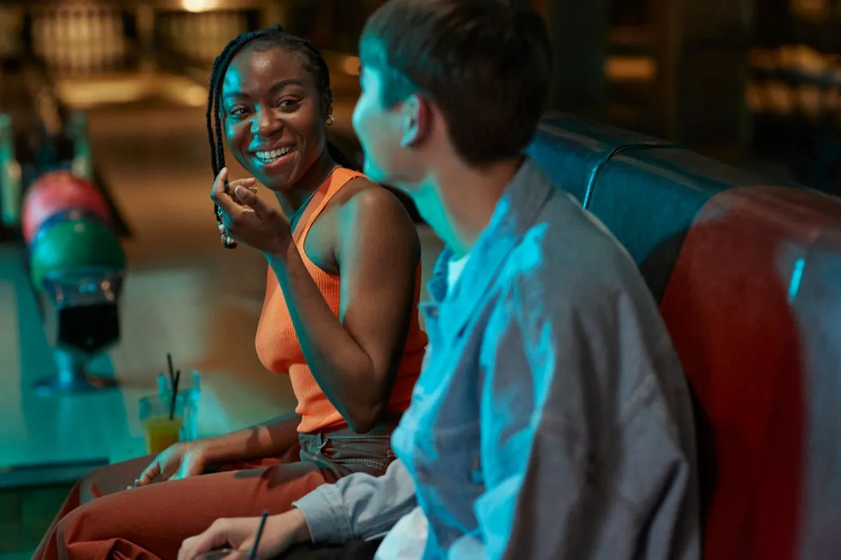 Two women smiling and talking in a diner booth