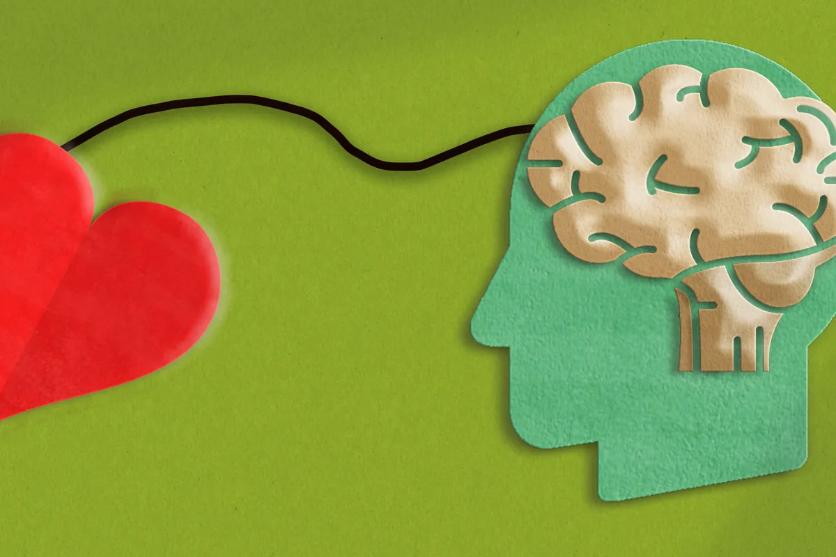 Paper-cut artwork of a red heart linked by a string to a head with a brain