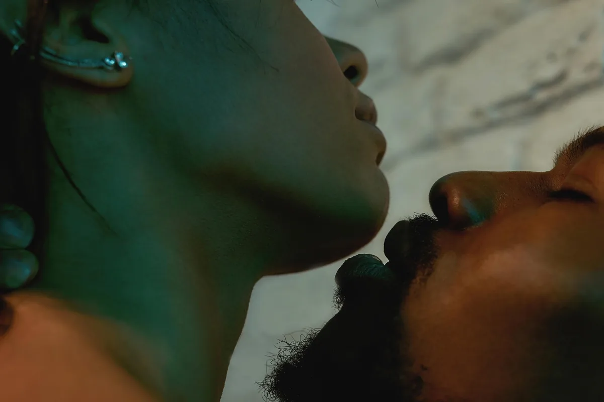 A couple about to kiss in soft green light