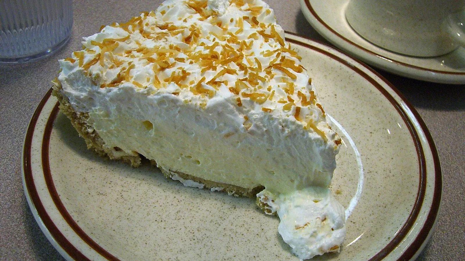 A slice of coconut cream pie on a diner plate